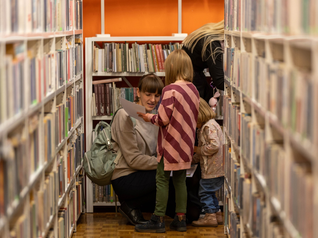 Fotografia przedstawia mieszkańc&oacute;w w bibliotece. 