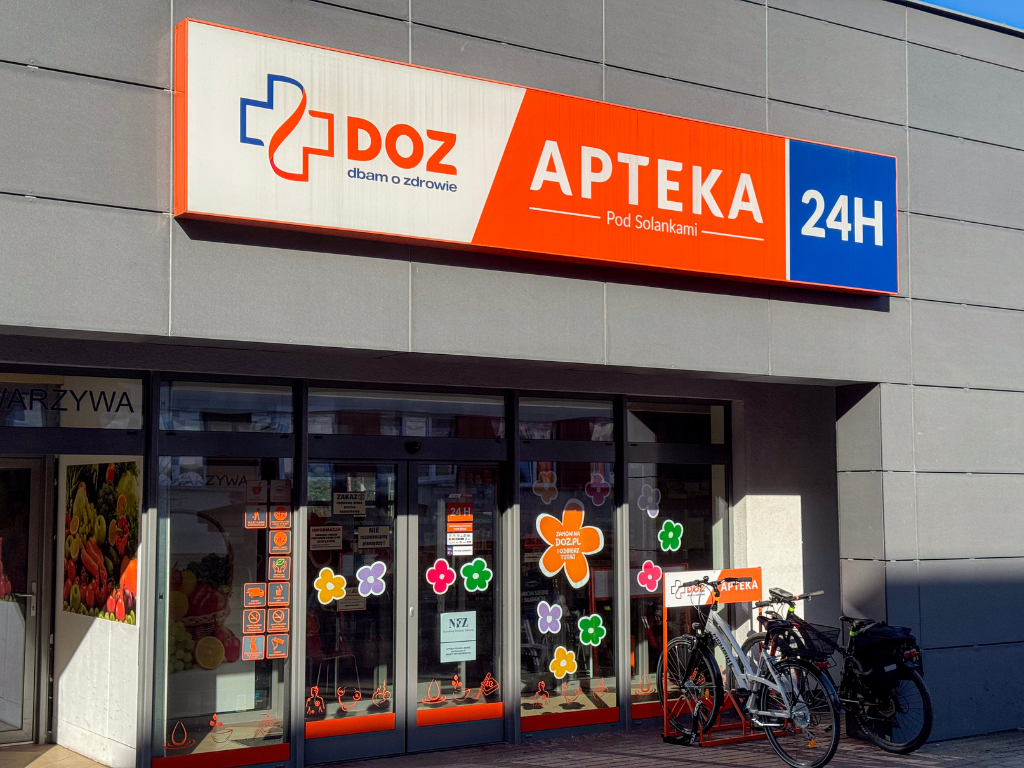 Fotografia przedstawia wejście do apteki. 