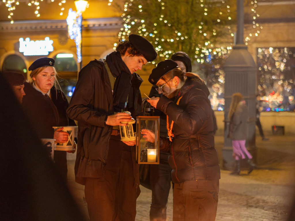 Fotografia przedstawia harcerzy, przekazujących Betlejemskie Światło Pokoju.