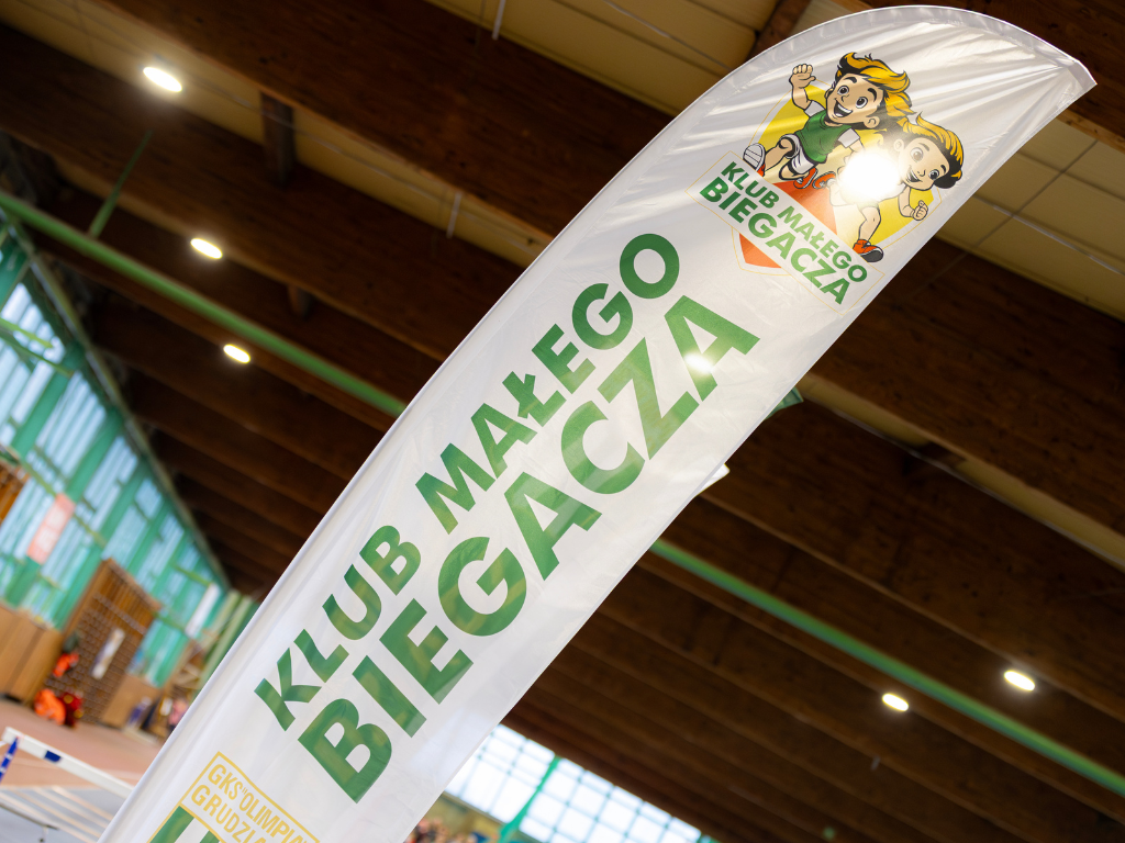 Fotografia przedstawia flagę promocyjną Klubu Małego Biegacza.